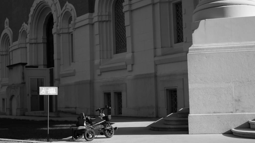 A tricycle in front of the stairs of the church. 